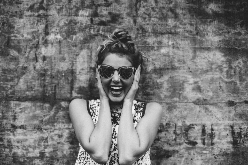 Femme heureuse se serrant la tête de surprise